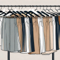 A variety of stylish trousers draped over a clothing rack